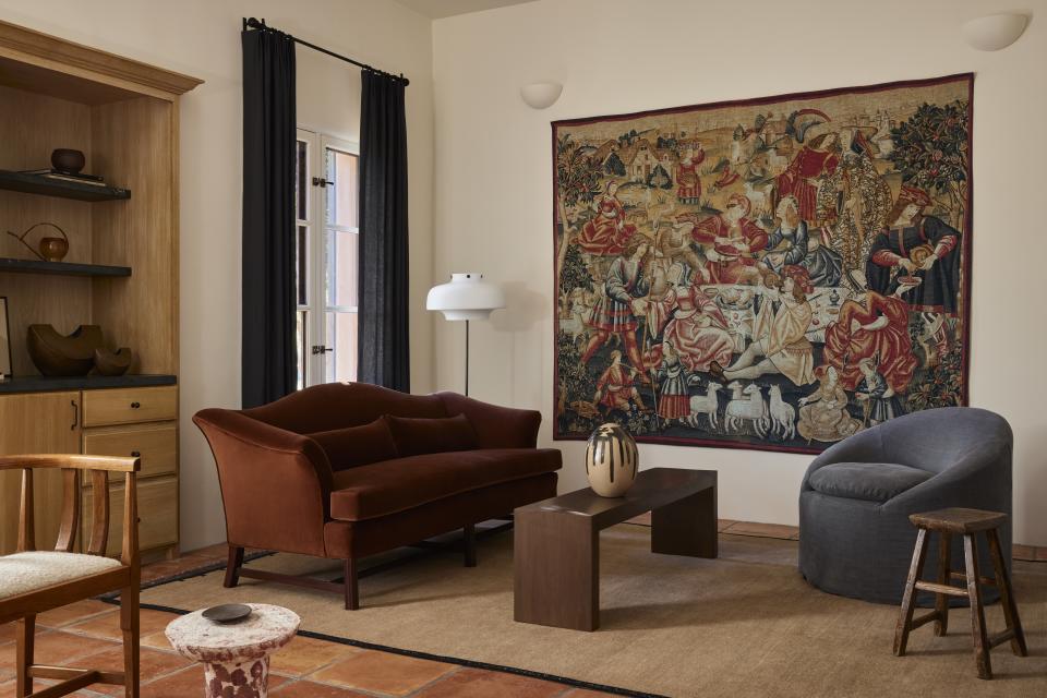 A living room with tapestry on the wall