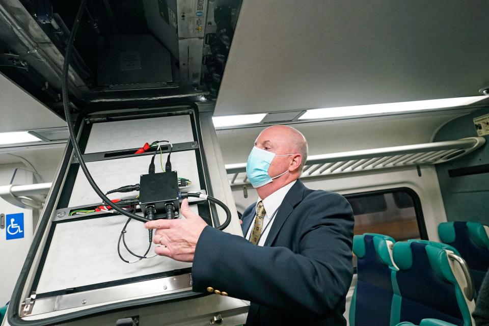 James Heimbuecher, MTA Metro-North Railroad's chief mechanical officer, demonstrates an air purification pilot program designed to remove airborne viruses and bacteria in enclosed spaces on MTA's Metro-North railroad cars, Thursday, Oct. 15, 2020, in New York. The MTA is the first transit agency in North America to test the technology. (AP Photo/Kathy Willens)