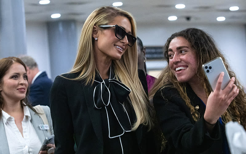 Paris Hilton walks through the basement of the Capitol with others