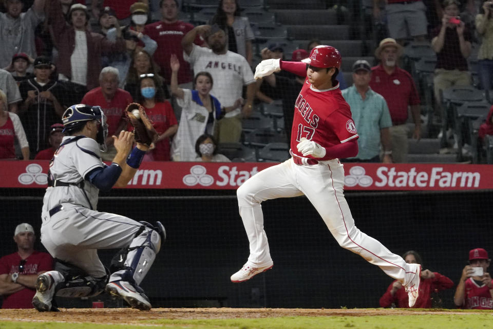 Los Angeles Angels designated hitter Shohei Ohtani, right, avoids a tag by Houston Astros catcher Jason Castro but misses the plate during the 10th inning of a baseball game Wednesday, Sept. 22, 2021, in Anaheim, Calif. Ohtani was later tagged out by Castro. (AP Photo/Mark J. Terrill)