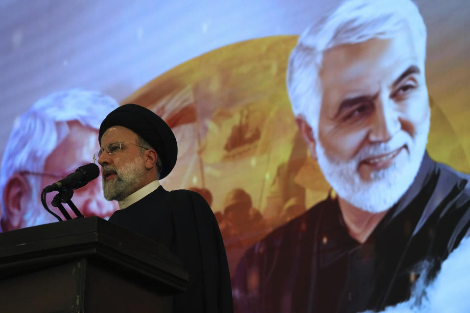 Iranian President Ebrahim Raisi addresses a ceremony marking anniversary of the death of the late Revolutionary Guard Gen. Qassem Soleimani, shown in the poster in background, who was killed in Iraq in a U.S. drone attack in 2020, at Imam Khomeini Grand Mosque in Tehran, Iran, Tuesday, Jan. 3, 2023. President Raisi vowed to avenge the killing of the country's top general, as the government rallied its supporters in mourning amid months of anti-government protests. (AP Photo/Vahid Salemi)