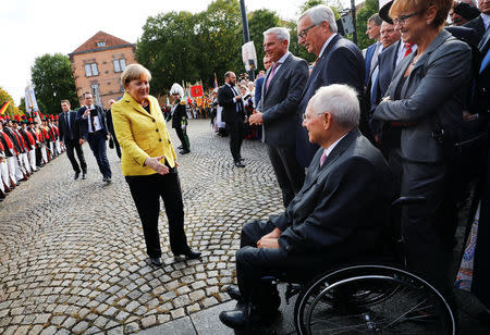 German Chancellor Angela Merkel congratulates German Finance Minister Wolfgang Schaeuble as they attend a gala reception organised by the CDU in Baden-Wuerttemberg to mark Schaeuble's 75th birthday in Offenburg, Germany, September 18, 2017. REUTERS/Kai Pfaffenbach