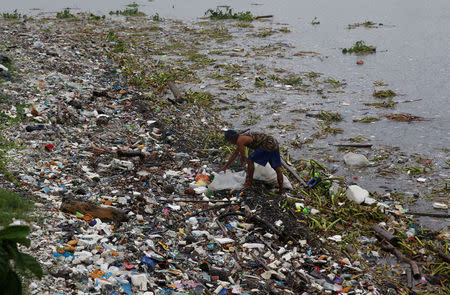 A resident collects recyclable materials from debris along the shore in Manila bay after Typhoon Sarika slammed central and northern Philippines, October 16, 2016. REUTERS/Erik De Castro