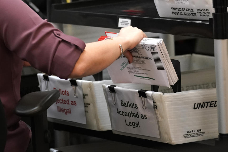 FILE - In this Oct. 26, 2020, file photo, an election worker sorts vote-by-mail ballots at the Miami-Dade County Board of Elections, in Doral, Fla. On Friday, Oct. 30, 2020, The Associated Press reported on stories circulating online incorrectly asserting that 23% of mail-in ballots have been rejected for missing signatures in Florida’s Miami-Dade County. The correct number is about 0.5%. (AP Photo/Lynne Sladky, File)