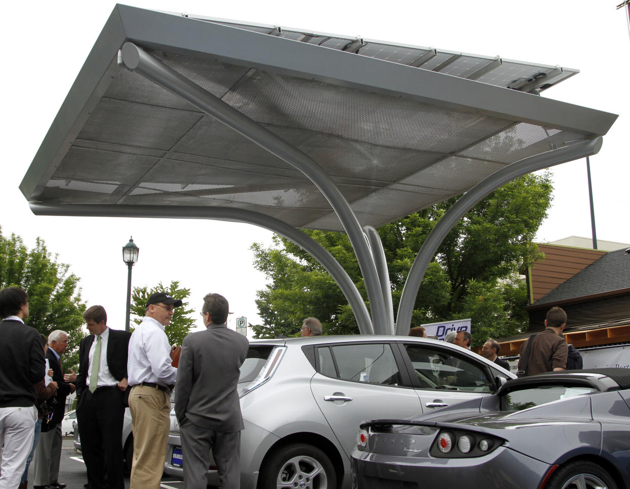 A solar canopy stands over Tesla, right,  and Nissan Leaf electric cars at the unveiling of a solar-powered electric car charging station in Portland, Ore., Wednesday, June, 8, 2011.  The grid-tied solar canopy, one of only two of its' kind in Portland, has two charging stations with the capacity to fully charge six electric vehicles a day.(AP Photo/Don Ryan)