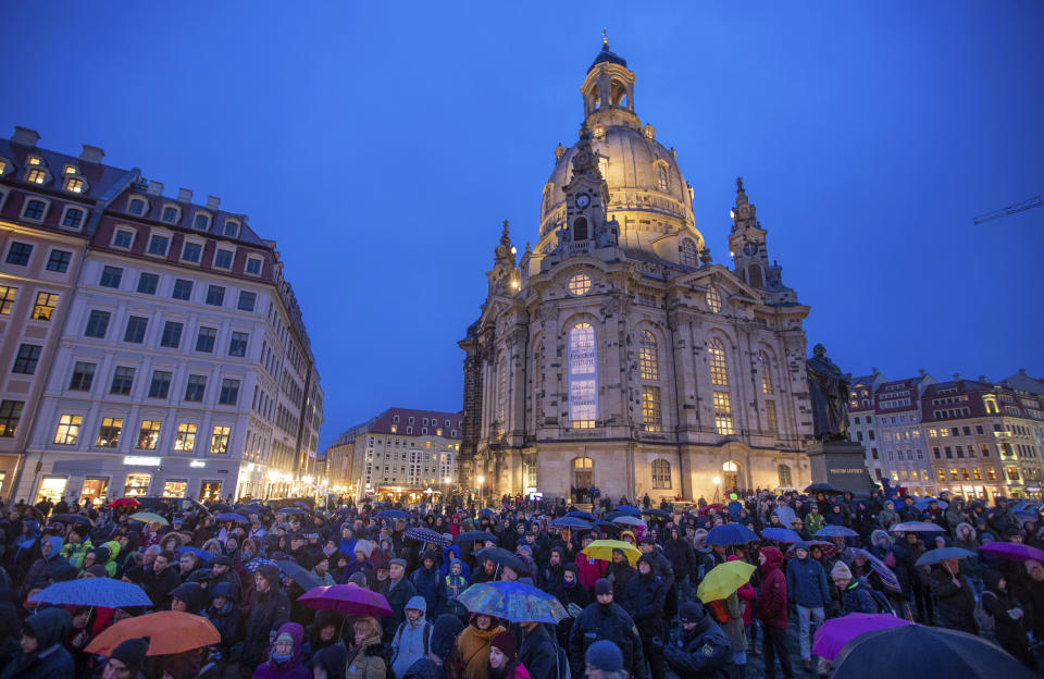 People gather in front of the Frauenkirche for the opening event of the human chain on the occasion of the 75th anniversary of the destruction of Dresden in the Second World War, in Dresden, Germany, Thursday Feb. 13, 2020. A 1945 allied bombing campaign reduced the centre of Dresden to rubble leaving up to 25,000 people dead. (Jens B'ttner/dpa via AP)