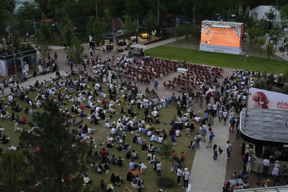 Spectators watch on screen Poland's Iga Swiatek playing Coco Gauff of the U.S. during the women final match of the French Open tennis tournament at the Roland Garros stadium Saturday, June 4, 2022 in Paris. (AP Photo/Christophe Ena)