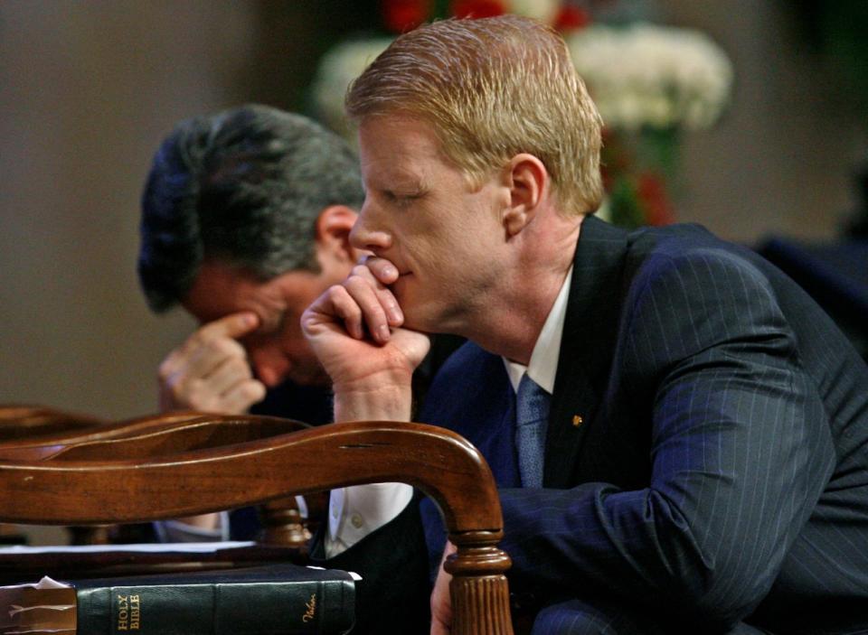 In this 2007 photo, Jonathan Falwell, right, and his brother Jerry Falwell Jr. pray after Jonathan delivered the sermon at the church founded by their late father in Lynchburg, Va.