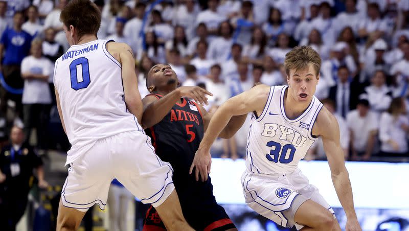 Brigham Young Cougars forward Noah Waterman (0) fouls San Diego State Aztecs guard Lamont Butler (5) as Brigham Young Cougars guard Dallin Hall (30) drives to the basket at BYU’s Marriott Center in Provo on Friday, Nov. 10, 2023.