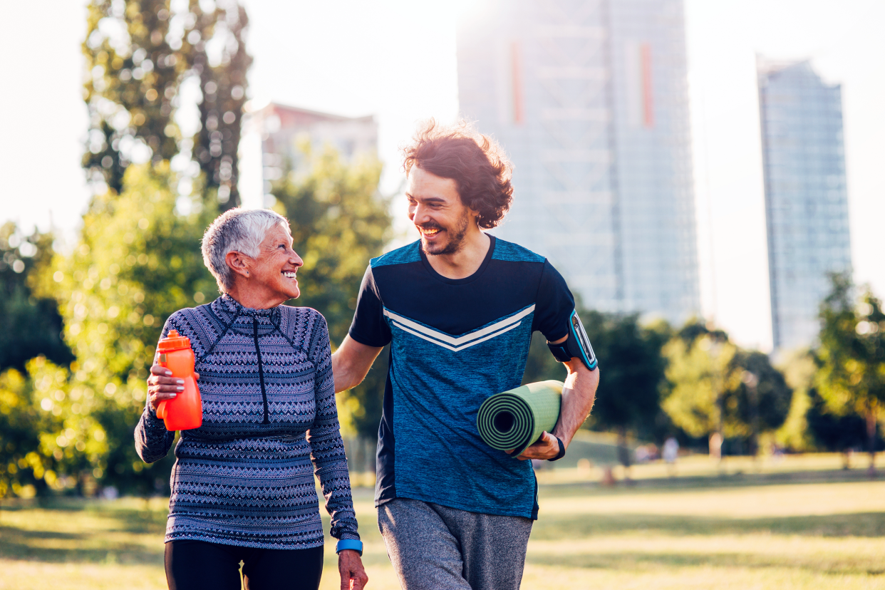 Fitness trainer speaking with an older woman walking outside