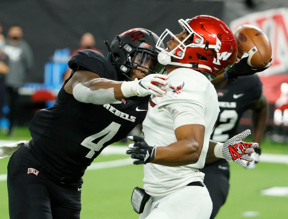 Quarterback Eric Barriere #3 of the Eastern Washington Eagles is hit as he throws by linebacker Jacoby Windmon #4 of the UNLV Rebels during their game at Allegiant Stadium on September 2, 2021 in Las Vegas, Nevada.