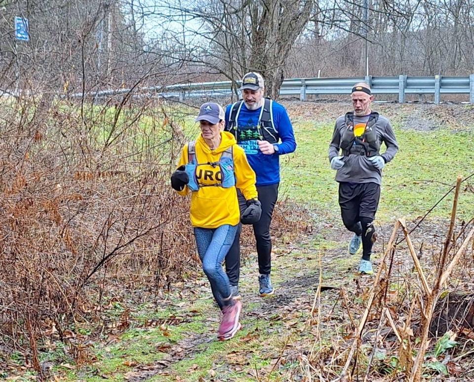 From left, Stephanie Daniels, Carl Leer and Ray Guzic go for a training run Jan. 27 on the trail around the Quemahoning Reservoir in Somerset County.