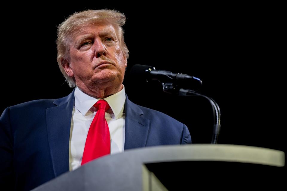 Former President Donald Trump stares into the crowd from the stage while addressing attendees of an American Freedom Tour rally in Austin, Texas.