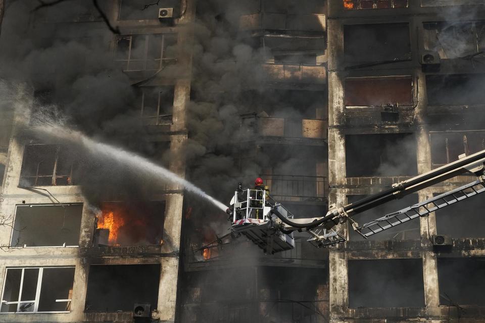 Feuerwehrleute arbeiten in einem durch Granatenbeschuss beschädigten Wohnhaus in Kiew, Ukraine. 15. März 2022