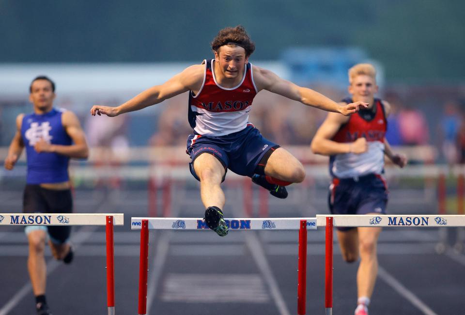Mason's AJ Martel clears the final hurdle as he wins the 300 meter hurdles during the MHSAA track and field 15-2 regional, Friday, May 19, 2023, at Mason High School.