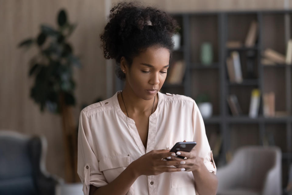 Young woman use smartphone text message online on modern gadget. Millennial mixed race female speak talk on video webcam call on cellphone device. Technology, communication concept.