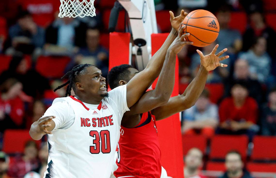 N.C. State’s D.J. Burns Jr. (30) knocks the rebound away from Louisville’s Brandon Huntley-Hatfield (5) during the first half of N.C. State’s game against Louisville at PNC Arena in Raleigh, N.C., Thursday, Dec. 22, 2022.