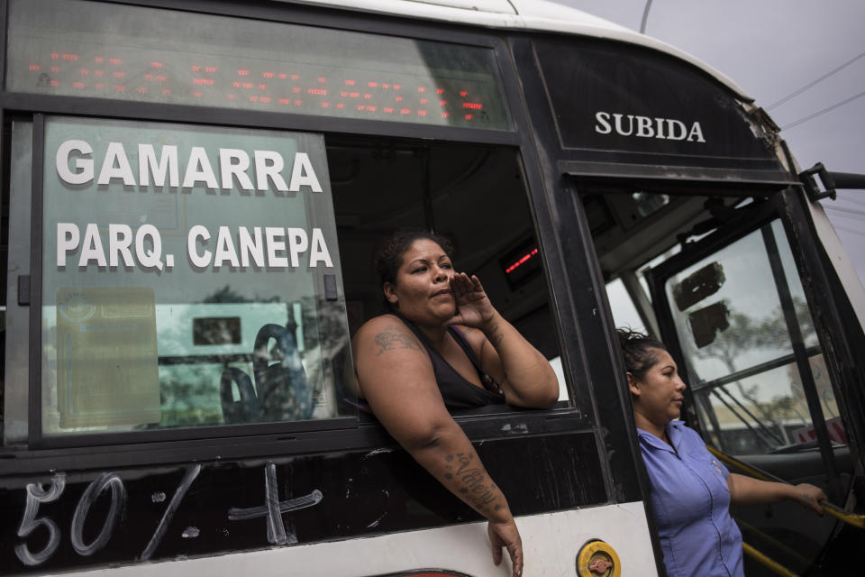 A woman in charge of charging the passenger tickets shouts indicating the bus route to the passers-by, in downtown in Lima, Peru, Wednesday, Jan. 22, 2020. Peru will hold elections on Jan. 26 for a new congressional body after President Martin Vizcarra dissolved congress exercising seldom used executive powers to shut down the opposition-controlled legislature that he accuses of stonewalling attempts to curb widespread corruption. (AP Photo/Rodrigo Abd)