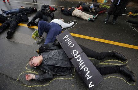 Demonstrators lay on the ground with chalk outlines to represent a mock crime scene during a protest marking the 100th day since the shooting death of Michael Brown in St. Louis, Missouri November 16, 2014. REUTERS/Jim Young