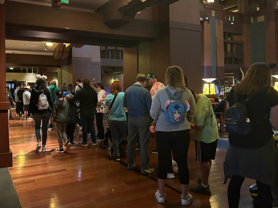 A long line of guests stretches through the hotel lobby.