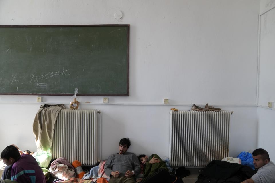 Migrants, most of them from Afghanistan, rest at an old school used as a temporary shelter on the island of Kythira, southern Greece, Thursday, Oct. 6, 2022. Bodies floated amid splintered wreckage in the wind-tossed waters off a Greek island Thursday as the death toll from the separate sinkings of two migrant boats rose to 22, with many still missing. (AP Photo/Thanassis Stavrakis)