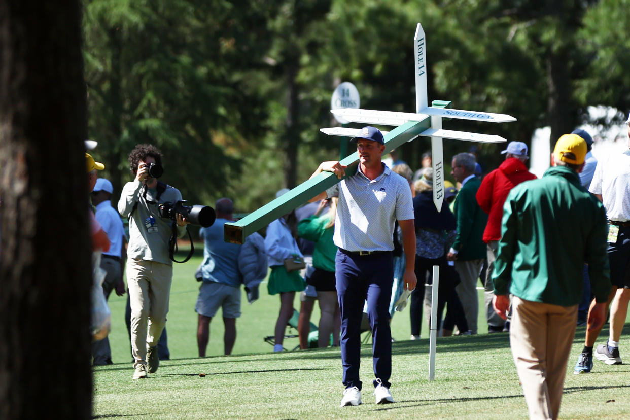 AUGUSTA, GEORGIA - APRIL 12: Bryson DeChambeau of the United States moves a sign while preparing to play his second shot on the 13th hole from the 14th fairway during the second round of the 2024 Masters Tournament at Augusta National Golf Club on April 12, 2024 in Augusta, Georgia. (Photo by Maddie Meyer/Getty Images)