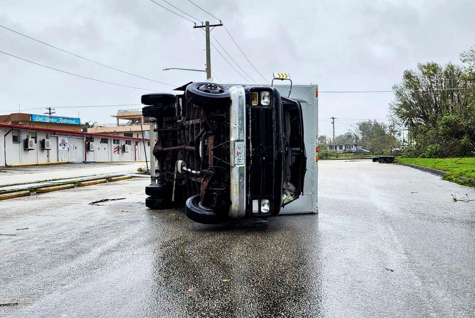 In this photo provided by Chris Leavitt, an overturned truck lies on a street Thursday, May 25, 2023, in Yigo, Guam, after Typhoon Mawar passed over the island (AP)