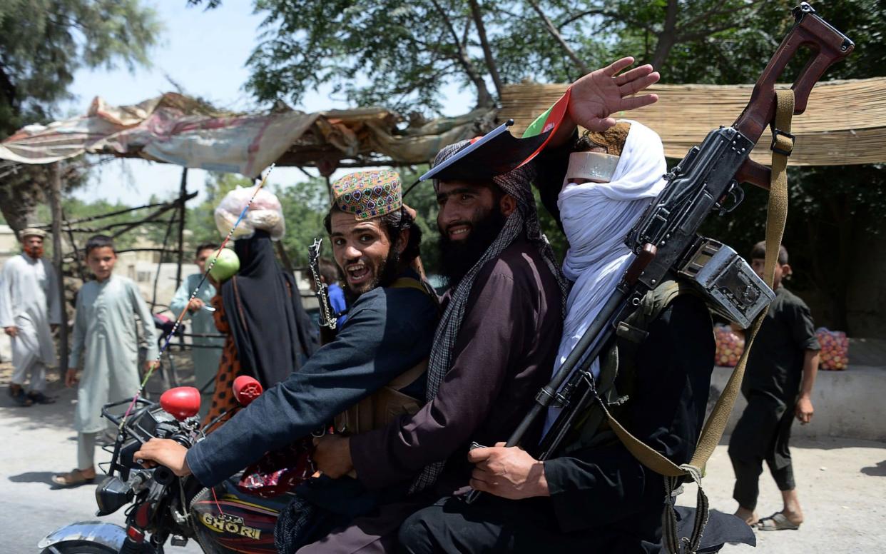 Afghan Taliban militants rode a motorbike as they took to the streets to celebrate a ceasefire on the second day of Eid - AFP