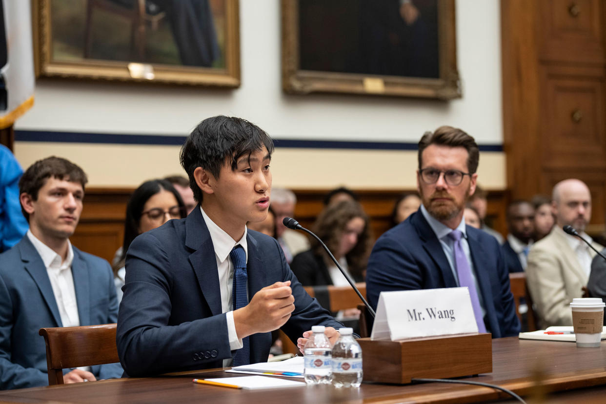 CEO of Scale A.I. Alexandr Wang behind a table speaking into a microphone during testimony