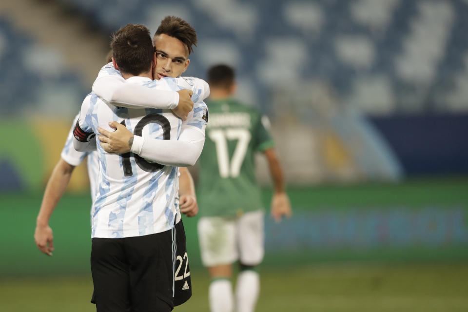 Argentina's Lautaro Martinez, center, celebrates scoring his side's 4th goal against Bolivia with teammate Lionel Messi during a Copa America soccer match at Arena Pantanal stadium in Cuiaba, Brazil, Monday, June 28, 2021. (AP Photo/Andre Penner)