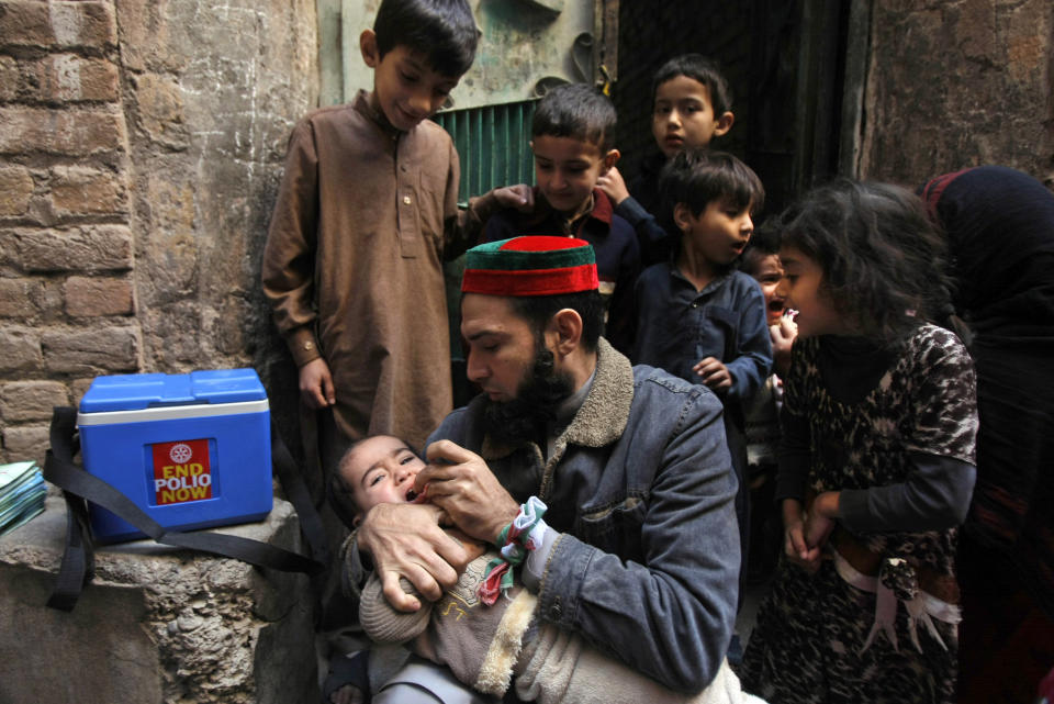 In this Feb. 9, 2014 photo, a Pakistani health worker vaccinates a child against polio, in Peshawar, Pakistan. Pakistan’s beleaguered battle to eradicate polio is threatening a global, multi-billion dollar campaign to wipe out the disease worldwide. Because of Pakistan, the virus is spreading to countries that were previously polio free, say U.N officials. “The largest poliovirus reservoir of the world,” is in Peshawar, the capital of Pakistan’s northwest Khyber Pukhtunkhwa province, which borders Afghanistan, according to the World Health Organization. (AP Photo/Mohammad Sajjad)