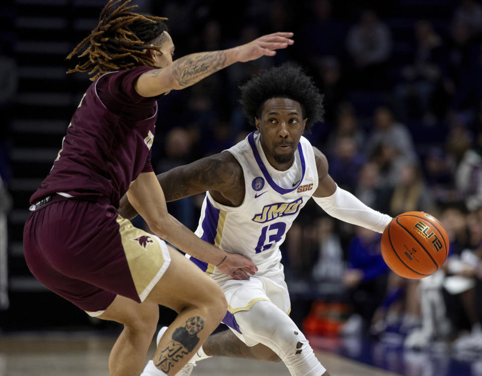 James Madison guard Michael Green III (13) tries to drive around Texas State guard Kaden Gumbs during the first half of an NCAA college basketball game in Harrisonburg, Va., Saturday, Dec. 30, 2023. (Daniel Lin/Daily News-Record via AP)