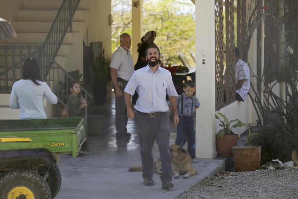 Unidentified people gather at the Christian Aid Ministries headquarters in Titanyen, north of Port-au-Prince, Haiti, Thursday, Dec. 16, 2021. Twelve remaining members of a Holmes County, Ohio-based missionary group who were kidnapped two months ago have been freed, according to the group and Haitian police. (AP Photo/Odelyn Joseph)