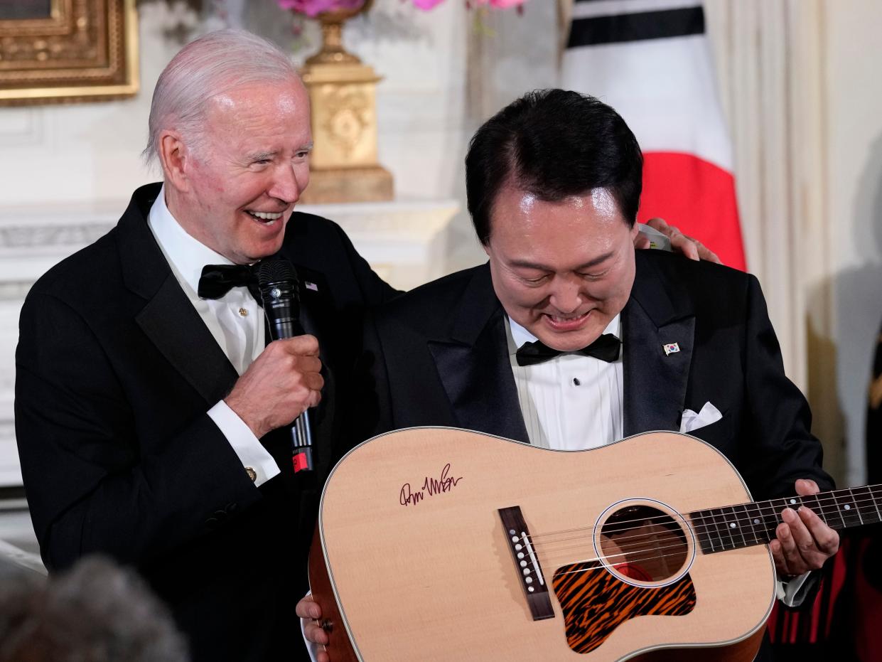 President Joe Biden surprises South Korea's President Yoon Suk Yeol with a guitar signed by Don McLean in the State Dining Room of the White House in Washington, Wednesday, April 26, 2023, following the State Dinner. American Pie, by McLean, is one of Yoon's favorite songs.