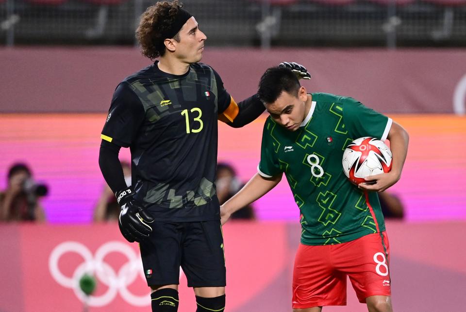 Mexico's goalkeeper Guillermo Ochoa (L) encourages Mexico's midfielder Carlos Rodriguez during the Tokyo 2020 Olympic Games men's semi-final football match between Mexico and Brazil at Ibaraki Kashima Stadium in Kashima city, Ibaraki prefecture on August 3, 2021. / AFP / PEDRO PARDO