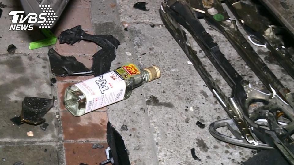 酒駕客車的駕駛座旁掉出一瓶高粱酒。(圖／TVBS)