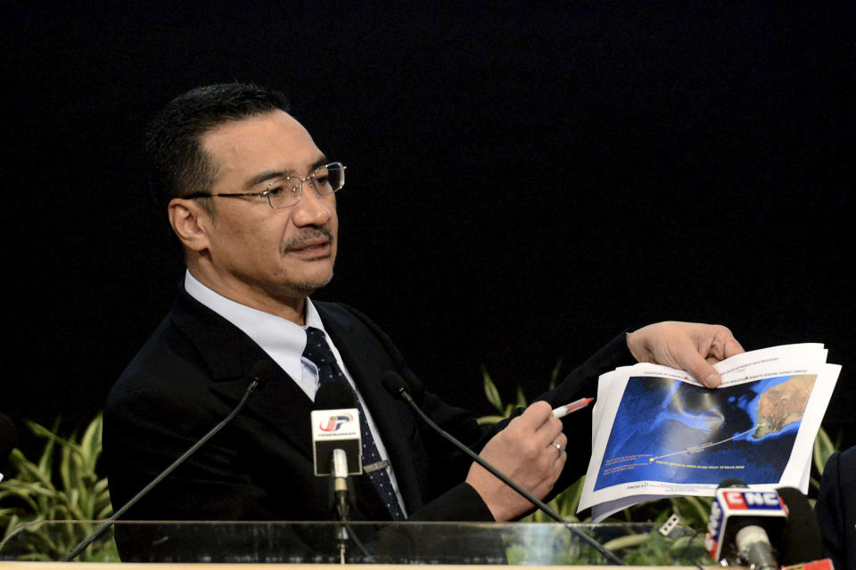 FILE - In this Wednesday, March 26, 2014 file photo, Malaysia's Defense Minister and acting Transport Minister Hishammuddin Hussein shows a printout of the latest satellite image of objects that might be from the missing Malaysia Airlines plane, at Putra World Trade Center in Kuala Lumpur, Malaysia. Hussein has been pressed on whether there might be any survivors. He has said he was still “hoping against hope” that passengers might be still found alive. This response was seen by some as contradictory to the Malaysian Airlines statement, creating a new discrepancy even on something which is fundamentally unknowable. (AP Photo/Joshua Paul, File)