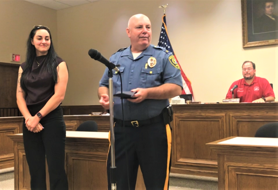 Pitman Borough police Officer Dominique Khoury receives her department's 2022 Officer of the Year from Chief Daniel McAteer at a meeting of the Borough Council on Monday night. Background: Mayor Michael Razze. PHOTO: August 14, 2023.
