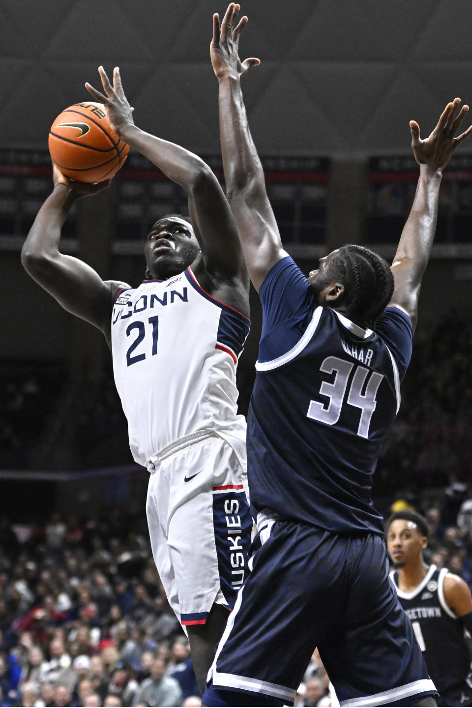 Connecticut's Adama Sanogo (21) shoots over Georgetown's Qudus Wahab (34) in the first half of an NCAA college basketball game, Tuesday, Dec. 20, 2022, in Storrs, Conn. (AP Photo/Jessica Hill)