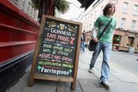 A man walks past a sign outside a pub in Temple Bar in Dublin.