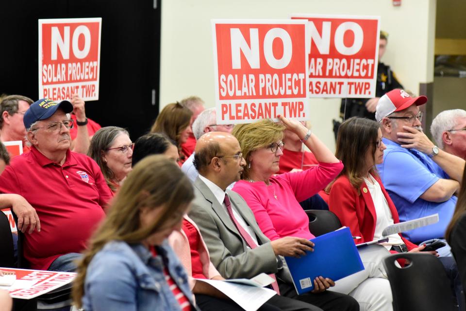 Opponents of the proposed solar farm in Marion County display signs during a public hearing on the matter Monday night at Tri-Rivers Career Center in Marion.