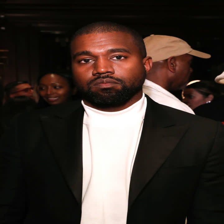 Headshot of Kanye in a black suit with white shirt