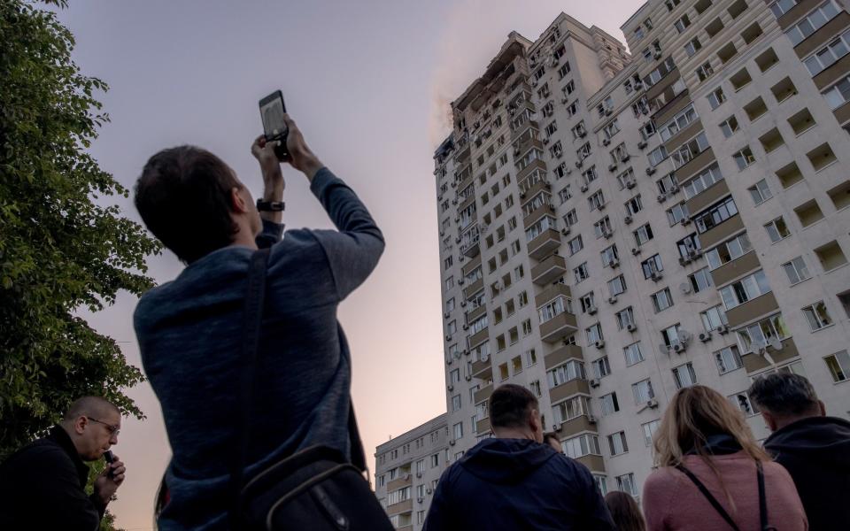 People gather outside a residential building damaged during Russian drone attacks in Kyiv - Roman Pilipey/Getty Images Europe