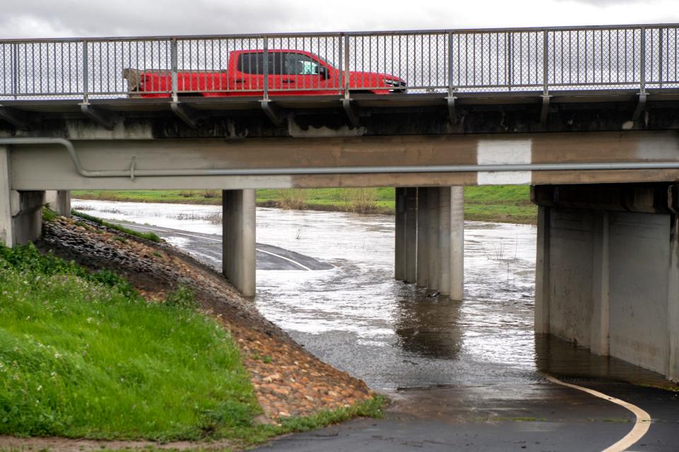 The storm-fed waters flood the Calaveras River Bike Path underpass at the Pacific Avenue bridge in Stockton on Tuesday, March 14, 2023.