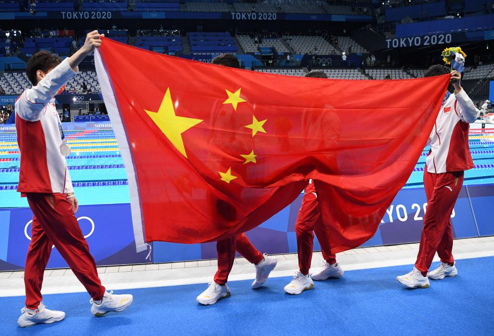 China's Xu Jiayu, China's Yan Zibei, Zhang Yufei and China's Yang Junxuan receive silver medals after the 2020 Tokyo Olympics mixed 4x100m medley relay final held at the Tokyo Aquatics Center in Tokyo in July and poses with a flag.  March 31, 2021.  (Photo by: Jonathan NACKSTRAND/AFP) (Photo by: JONATHAN NACKSTRAND/AFP, Getty Images)