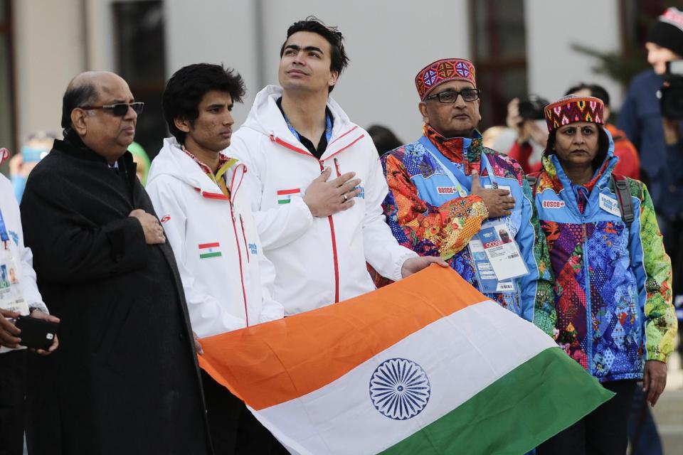 Newly elected Indian Olympic Association President Narayna Ramachandran, left, and members of the Indian Olympic team, alpine skier Thakur Himanshu, second left, and luger Shiva Keshavan, center, listen to the Indian national anthem during a welcome ceremony at the Mountain Olympic Village on Sunday, Feb. 16, 2014, during the 2014 Winter Olympics in Krasnaya Polyana, Russia. (AP Photo/Jae C. Hong)