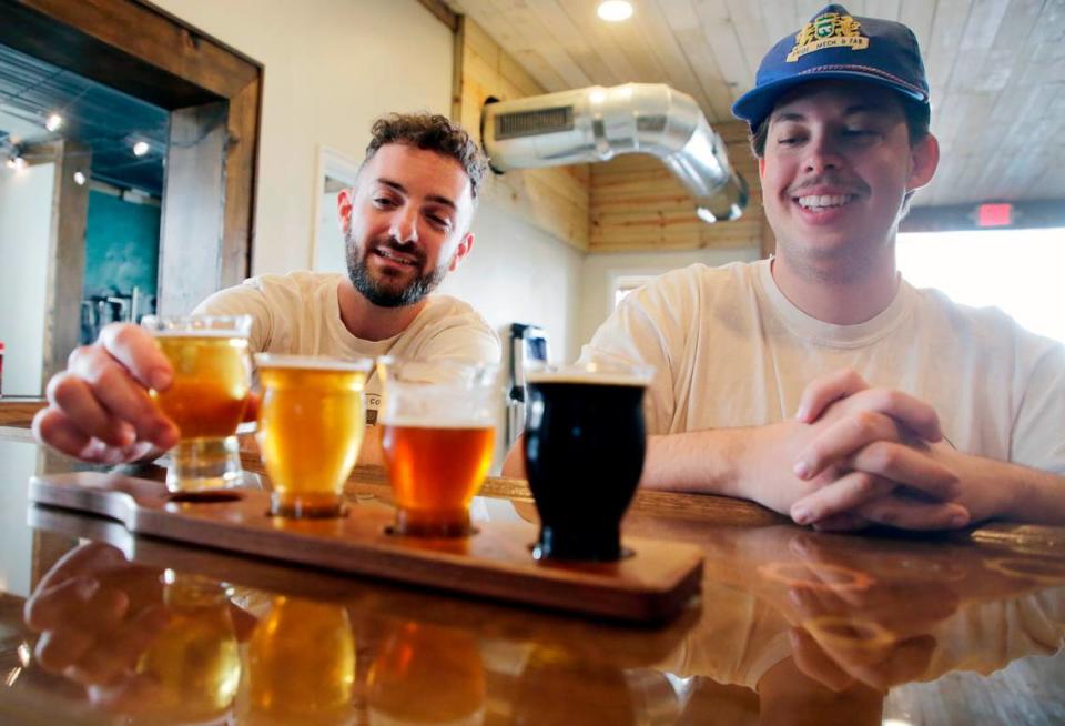 Jordan McCraw, left, event services manager for Visit York County tests out a sample of beer as intern Logan Elrod watches Thursday at Working Theory Beer in York.