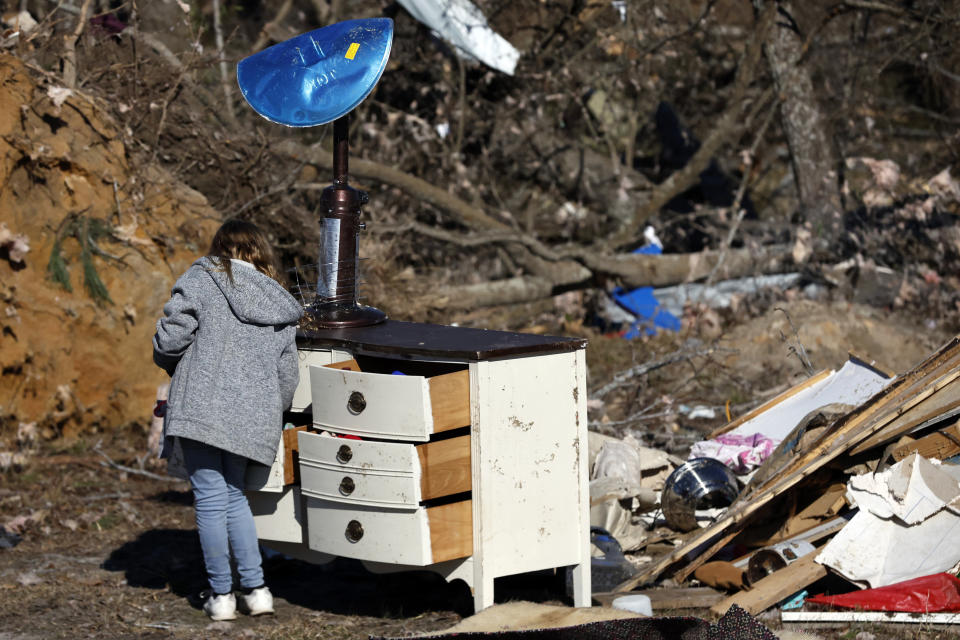 Brayleigh Johnson looks through her dresser for personal items as they recover from a tornado that ripped through Central Alabama earlier this week Saturday, Jan. 14, 2023 in Marbury, Ala. Stunned residents tried to salvage belongings as rescue crews pulled survivors from the aftermath of a deadly tornado-spawning storm system. (AP Photo/Butch Dill)
