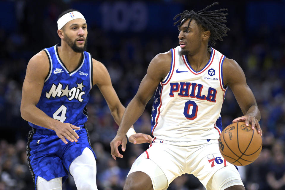 Philadelphia 76ers guard Tyrese Maxey (0) is defended by Orlando Magic guard Jalen Suggs (4) during the first half of an NBA basketball game Friday, Jan. 19, 2024, in Orlando, Fla. (AP Photo/Phelan M. Ebenhack)