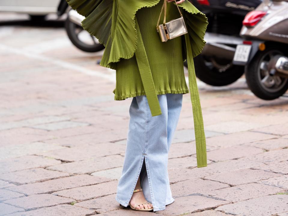 atyana Kodzayeva is seen wearing a sculptured green dress over denim pants.